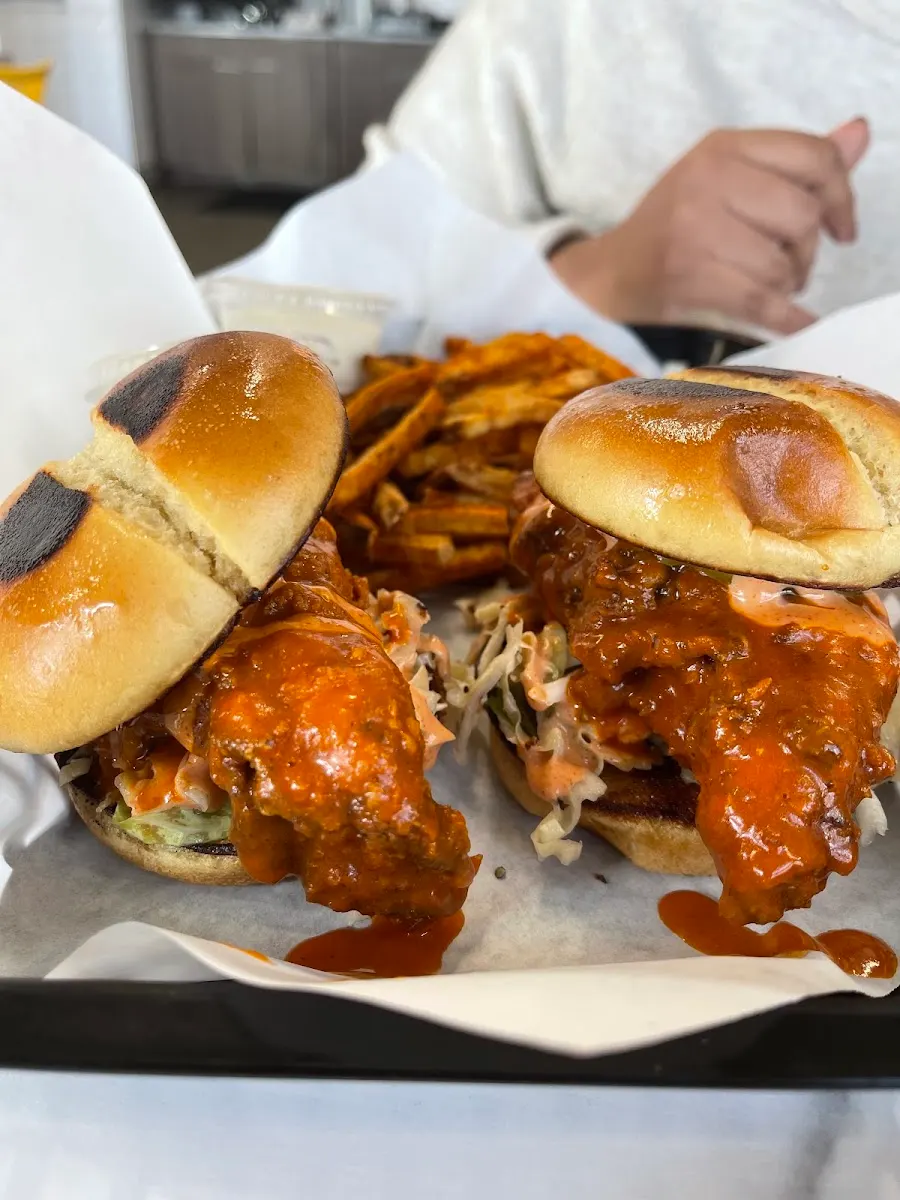 Customer photo: two saucy buffalo chicken sandwiches with seasoned fries at Wing Kings Zaragoza